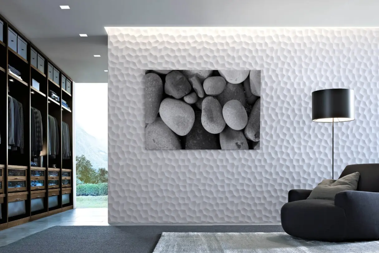 Kleedkamer met een witte 3D-wand met kiezelreliëf en een ingelijste foto