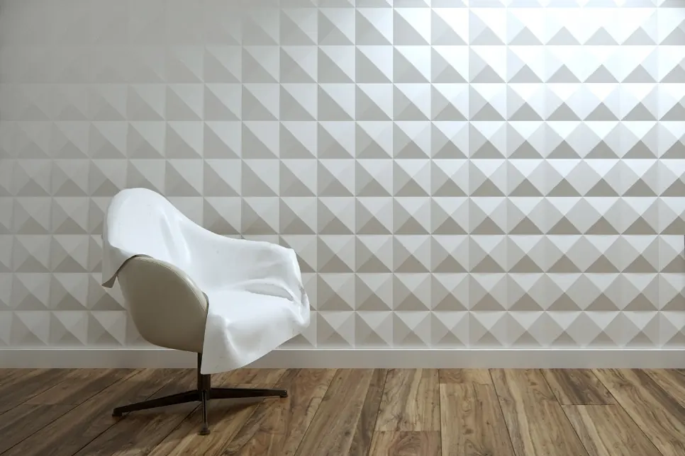 Witte kuipstoel tegen een 3D-wand met piramidevlakken in een raster